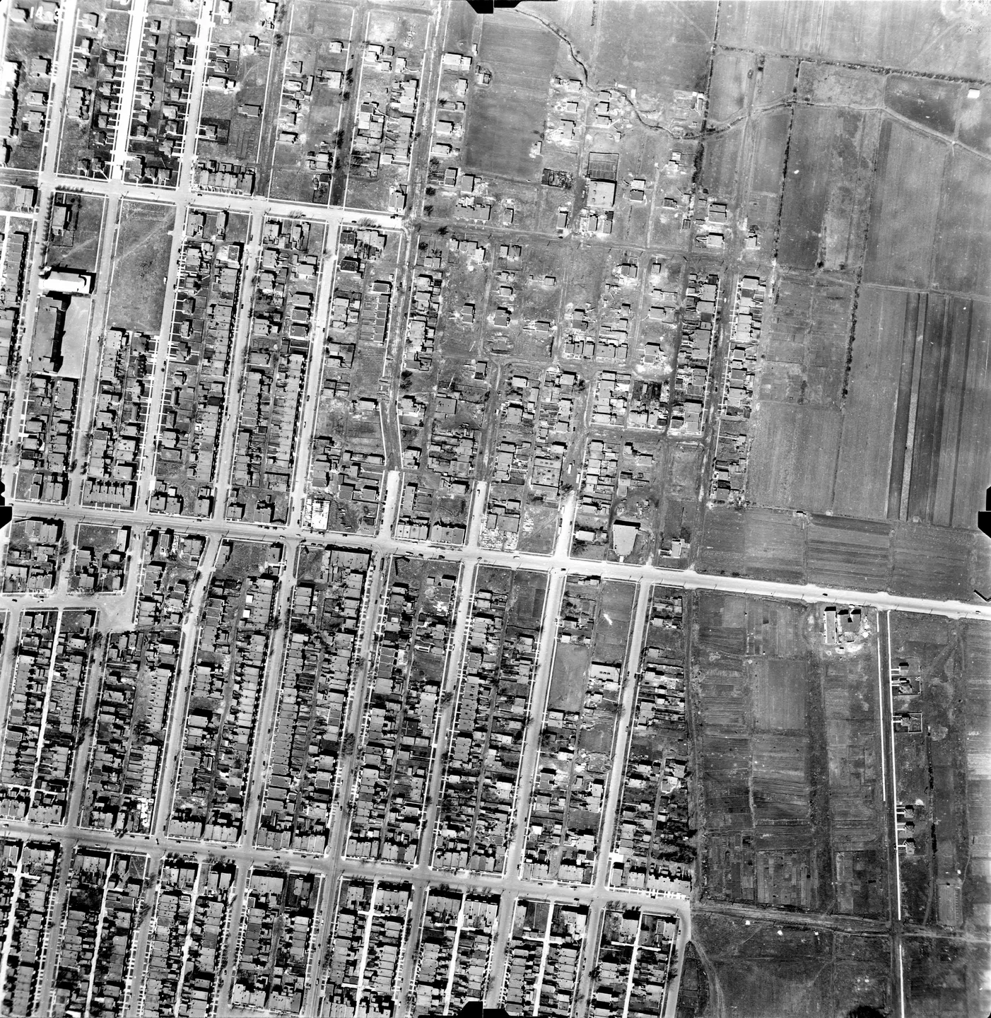 Rue en noir et blanc avec des bâtiments et plusieurs voitures garées