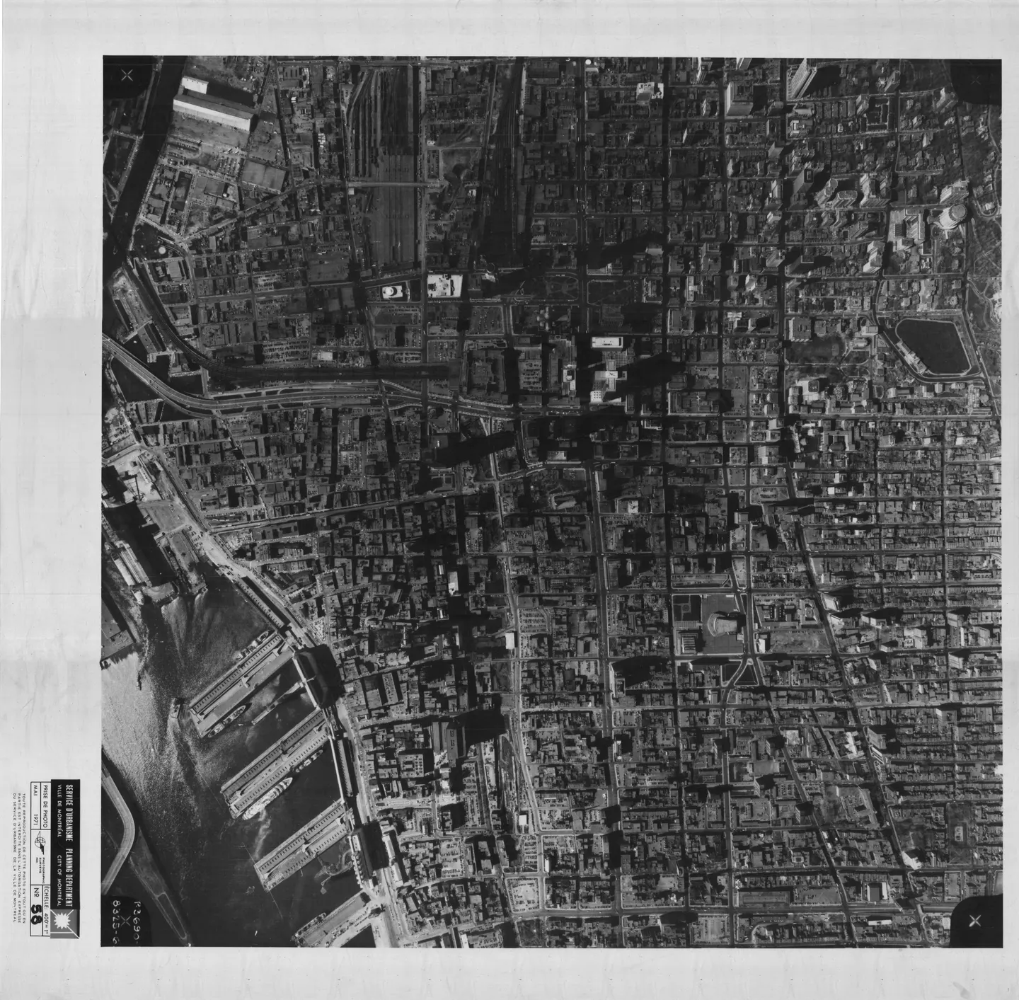 Photo noir et blanc d'une rue de Montréal remplie de bâtiments et de voitures garées