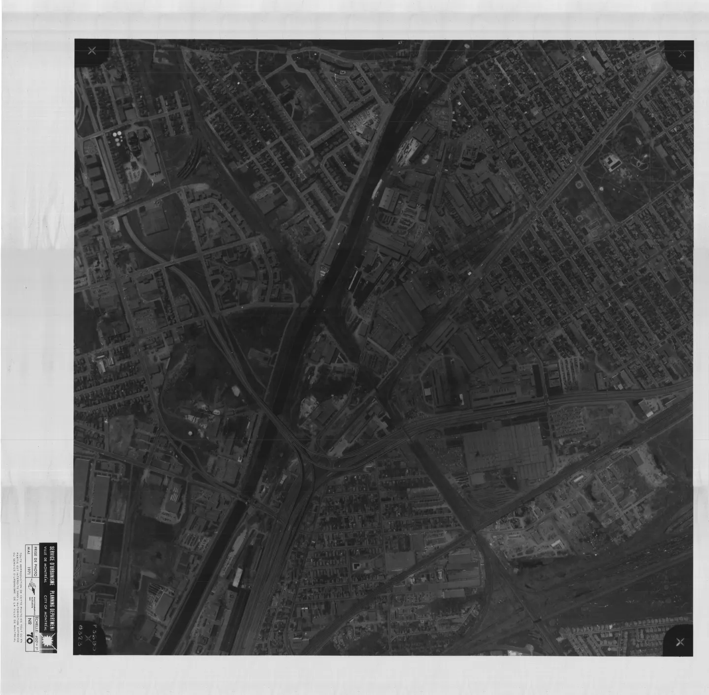 Photo en noir et blanc d'une rue de Montréal avec des bâtiments et une rivière à proximité