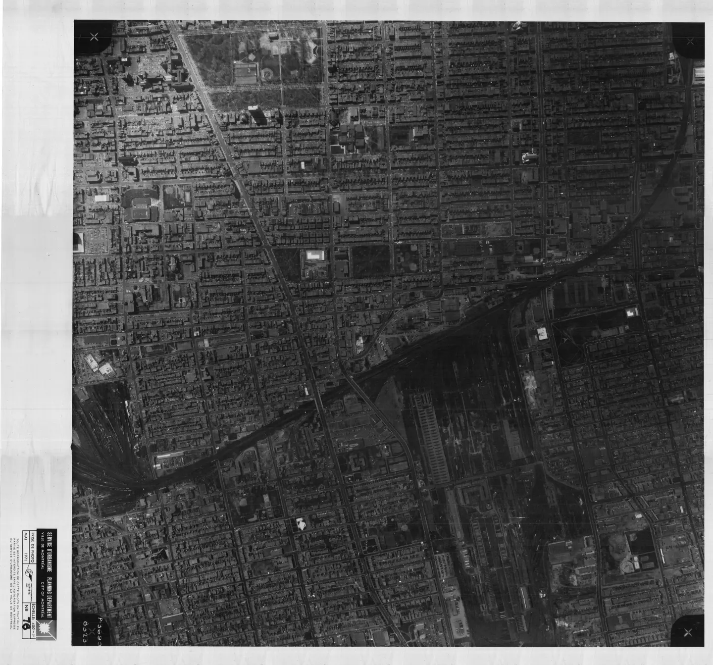Photo en noir et blanc d'une rue bordée de bâtiments et de voitures garées