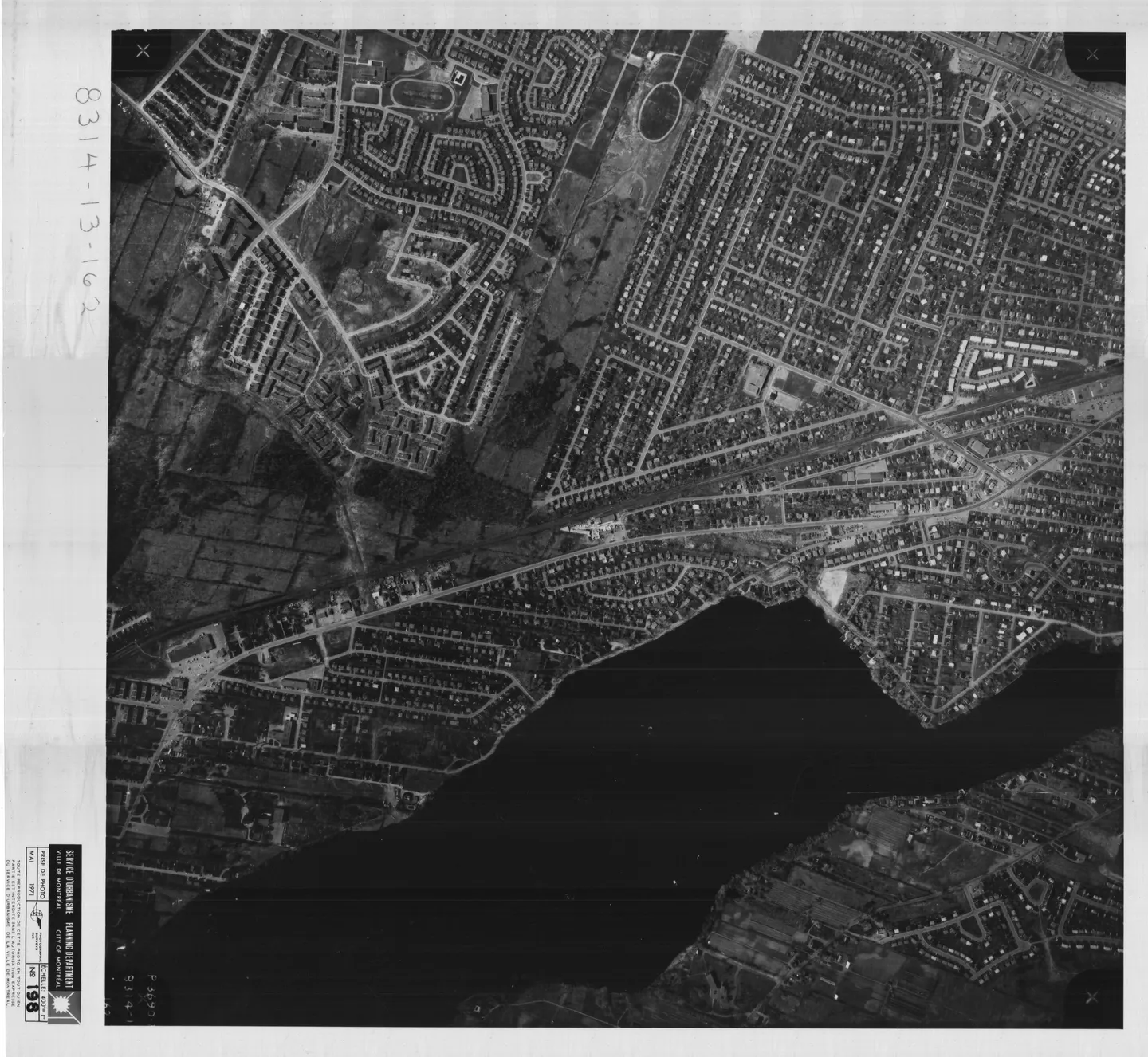 Photo en noir et blanc d'une rue avec maisons, bâtiments et voitures, vue aérienne