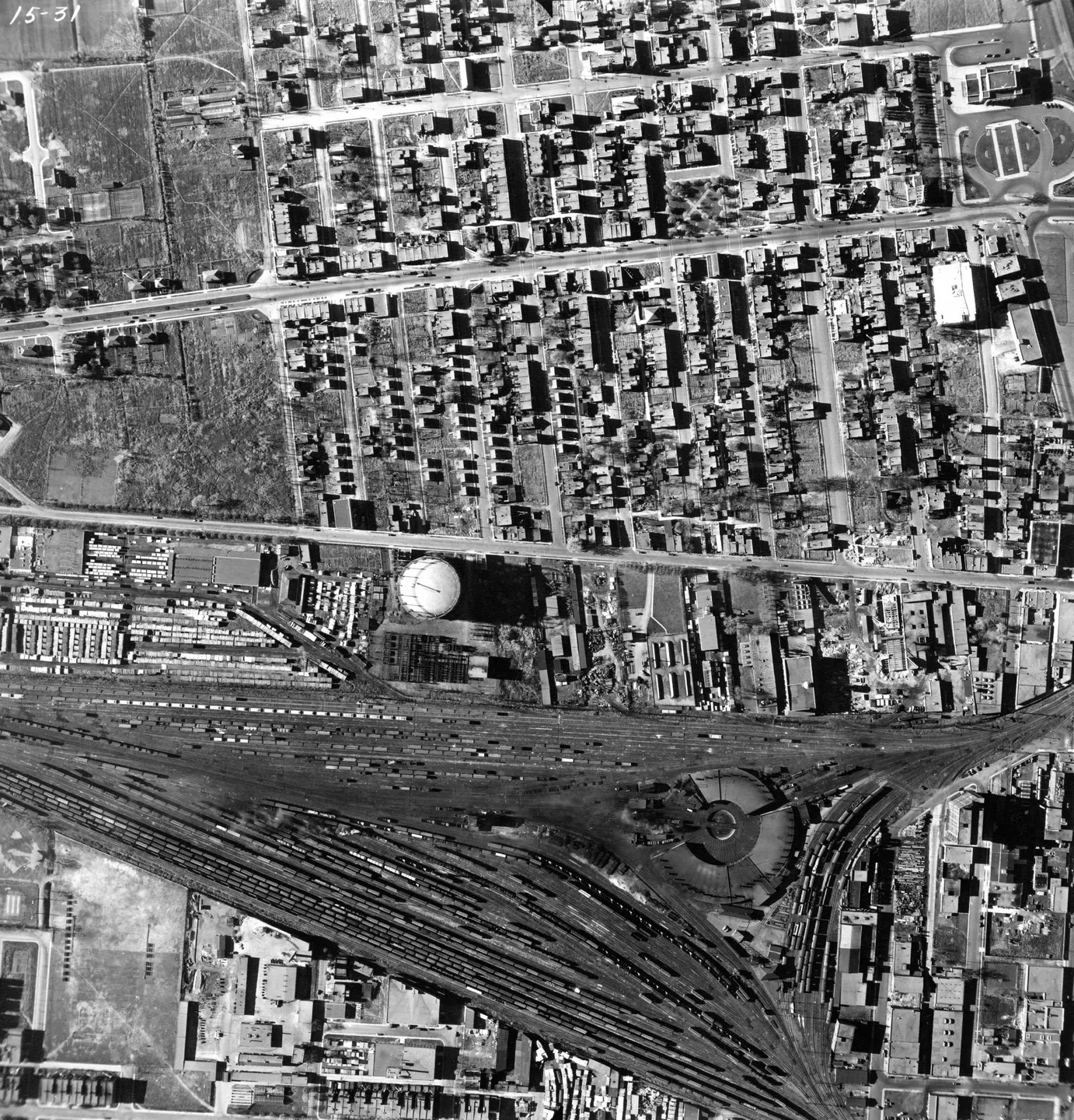 Vue aérienne en noir et blanc d’une rue de Montréal avec un grand dôme, bâtiments, voitures et piétons