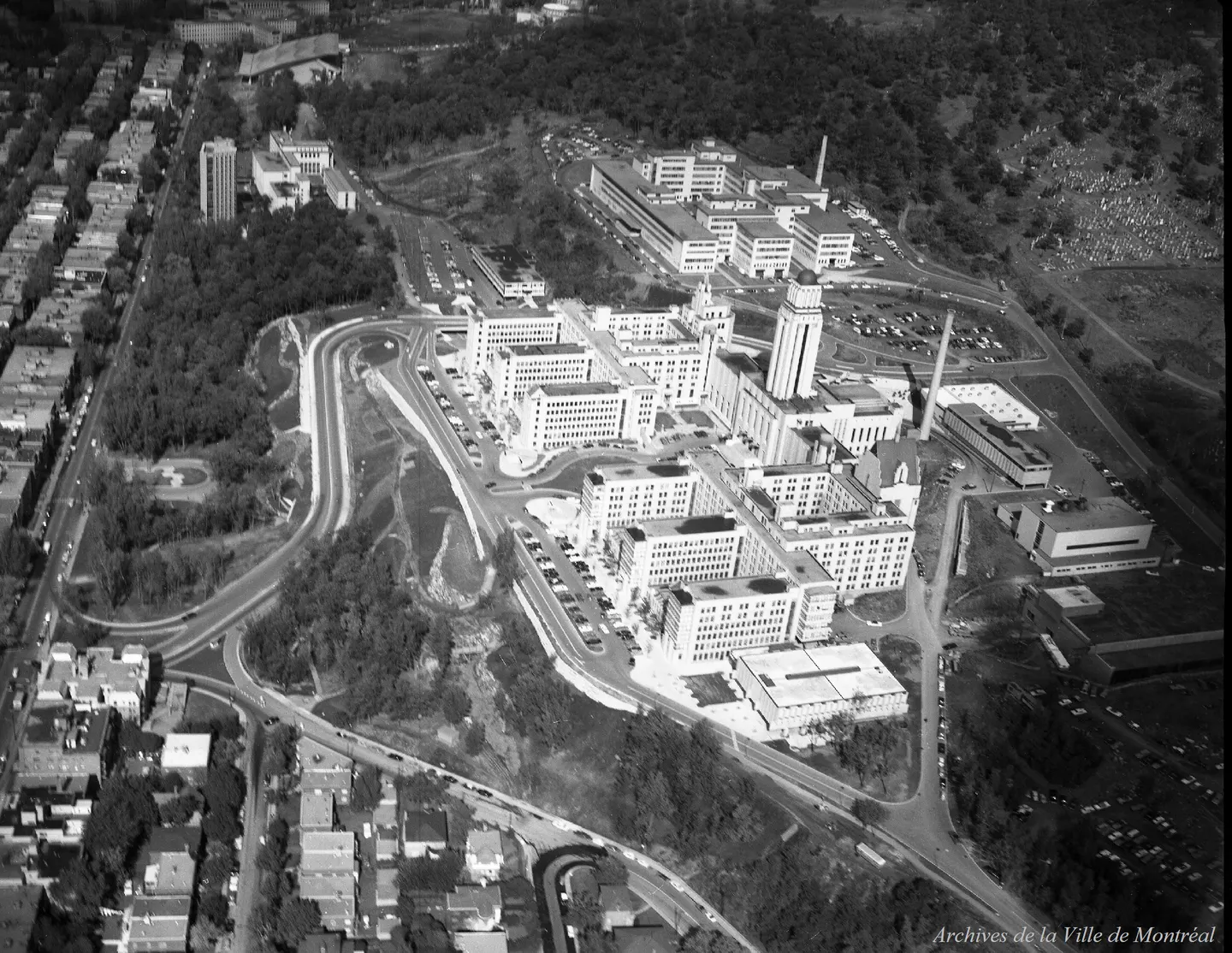 Photo aérienne d’un complexe institutionnel à Côte-des-Neiges, vue oblique, avec des routes courbes et une pente boisée