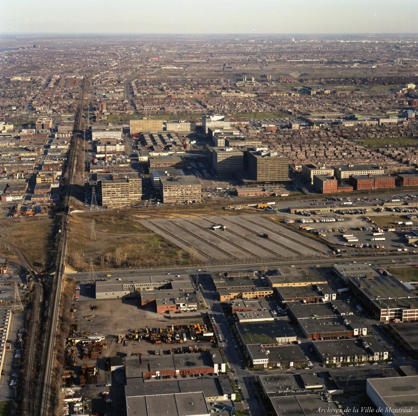Vue aérienne d’une rue de Montréal avec des bâtiments et plusieurs voitures garées.