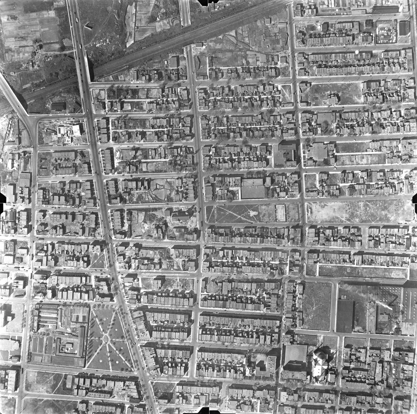 Aerial view of a street lined with buildings and parked cars
